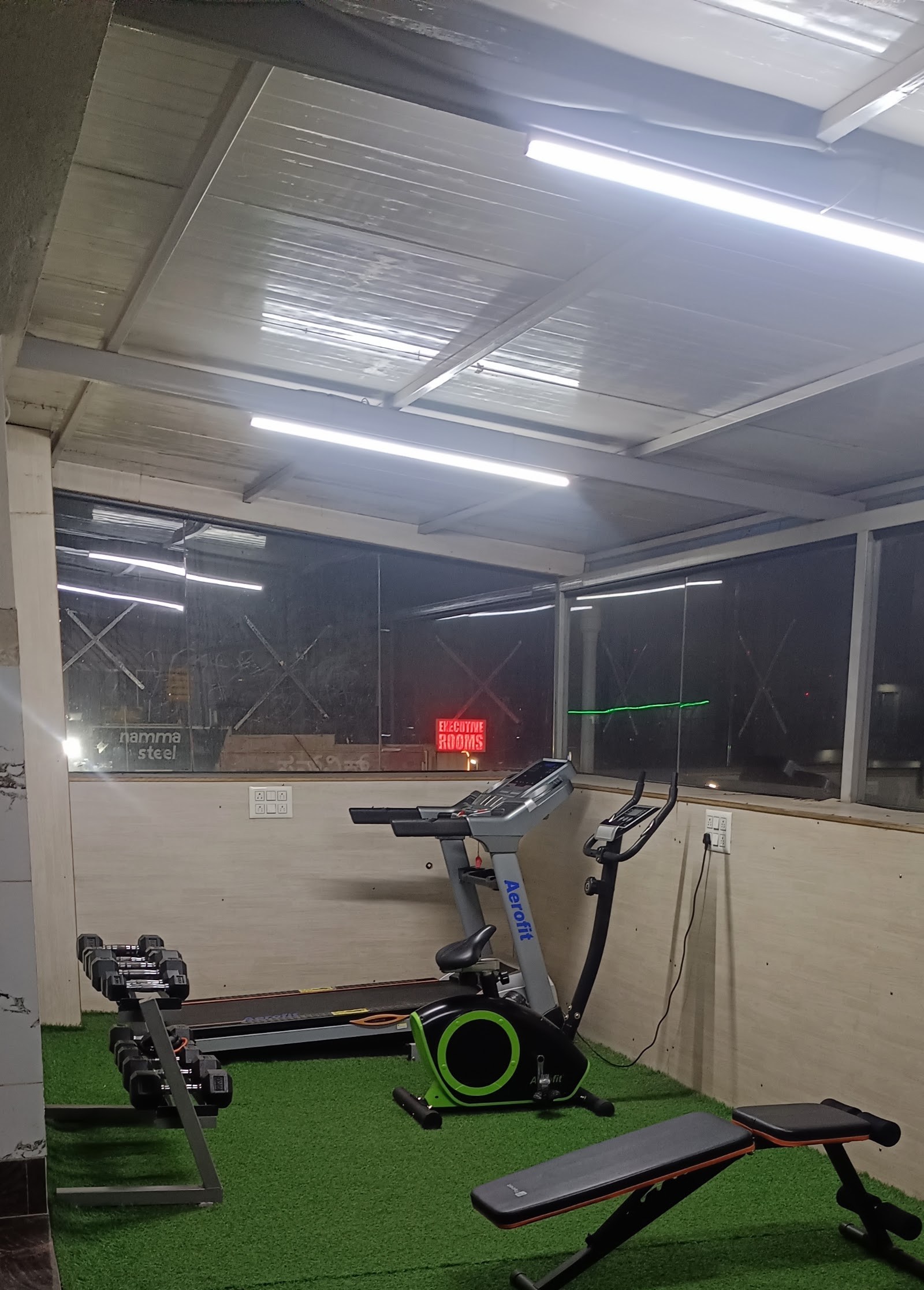 Rooftop gym with treadmill, exercise bike and weights at At Home PG