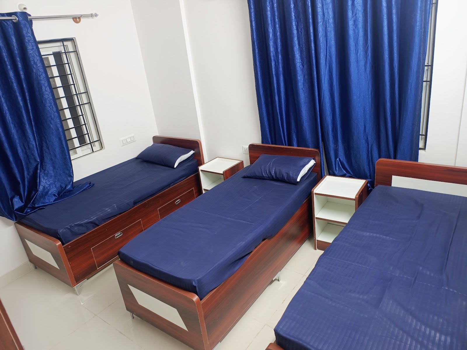 Sharing room with beds and curtains at At Home PG